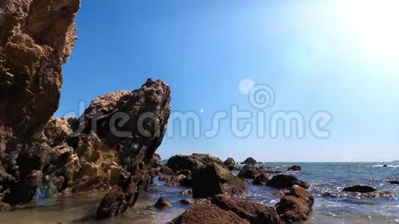 夏季用石头和岩石缓慢移动的海浪海岸到海滩视频的预览图