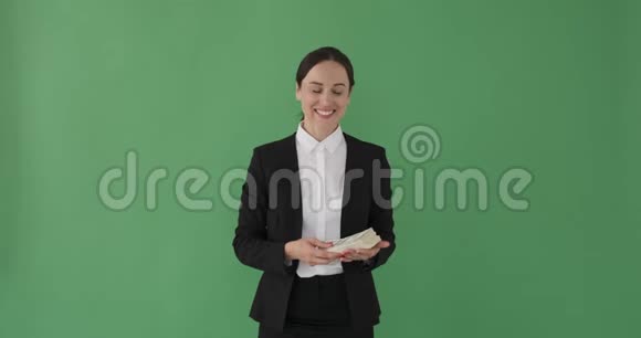 快乐的女商人手里拿着一捆美元视频的预览图