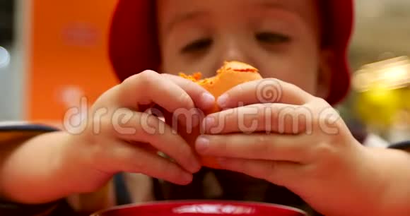 手里拿着蛋糕戴着巴拿马帽子的可爱孩子视频的预览图