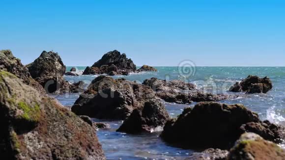 夏季用石头和岩石缓慢移动的海浪海岸到海滩视频的预览图