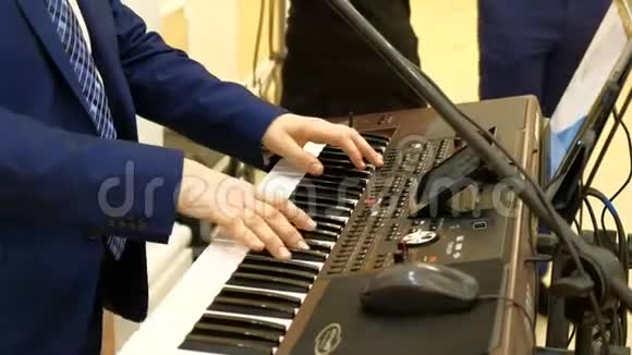 穿蓝色连衣裙的音乐家在数字钢琴上弹奏视频的预览图