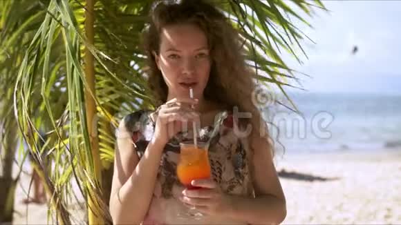 令人满意的女士在热带海滩喝鸡尾酒视频的预览图