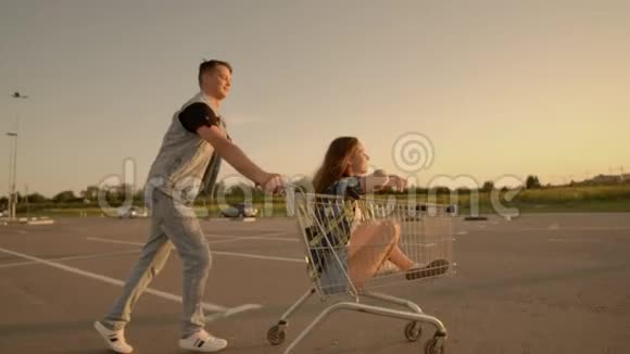 年轻浪漫的一对夫妇在晚上玩超市手推车英俊的胡子男和迷人的年轻视频的预览图