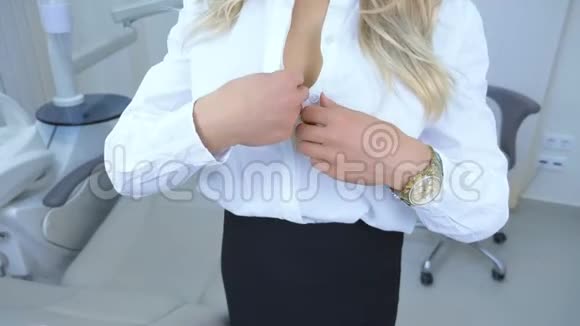 特写镜头在医生办公室里女人把一件衬衫系在胸前视频的预览图