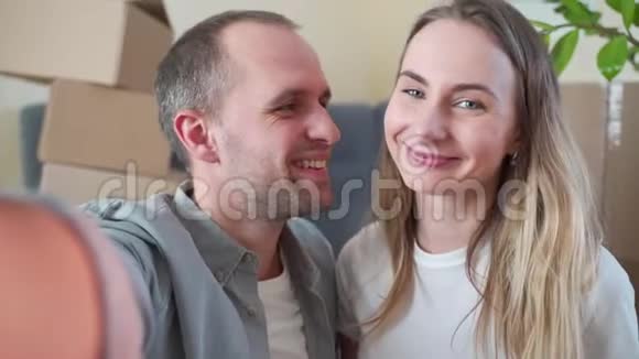 年轻的幸福夫妇展示了新家的钥匙看着摄像机视频的预览图