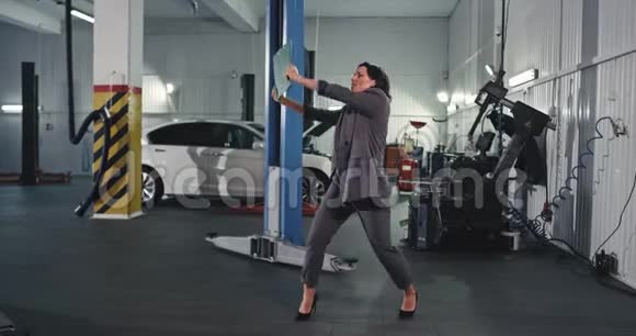 一位穿西装的美女在现代汽车服务中心大赚一笔后跳得很开心视频的预览图