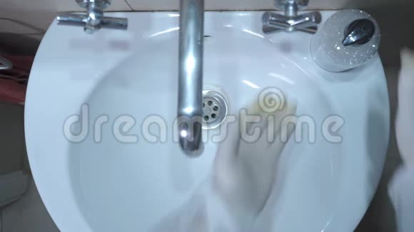 那个人在浴室里用橡胶手套和液体肥皂洗手冠状病毒概念视频的预览图