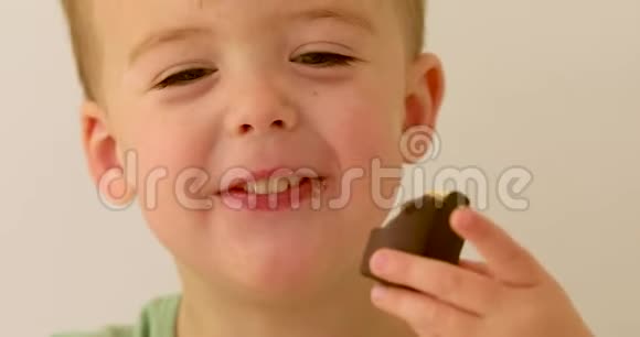 快乐的孩子笑着吃巧克力视频的预览图