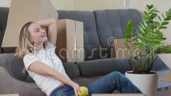 快乐的年轻女人搬到新家玩得开心一个女人扔苹果视频的预览图