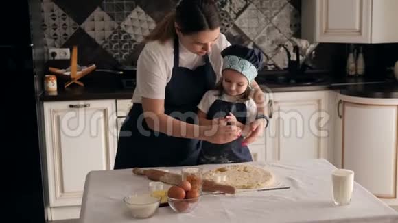 母亲和女儿从厨房的面团里切出不同的饼干形状视频的预览图