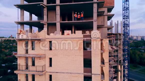 建筑师站在一栋正在建造的多层房子里视频的预览图