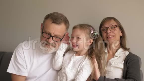 家庭肖像祖父母和孙子在家玩得开心一起笑祖父坐着微笑视频的预览图