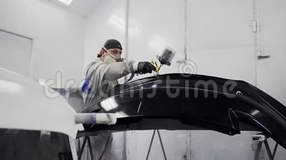 工人正在油漆喷漆间内油漆汽车保险杠视频的预览图