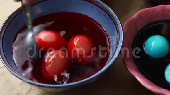 在桌子上用红色和蓝色的颜料画复活节彩蛋视频的预览图