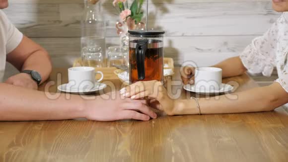 女人抚摸男人的手在舒适的餐厅约会视频的预览图