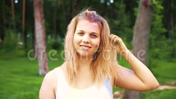 微笑的金发女孩在霍利节上洒上五颜六色的粉末视频的预览图