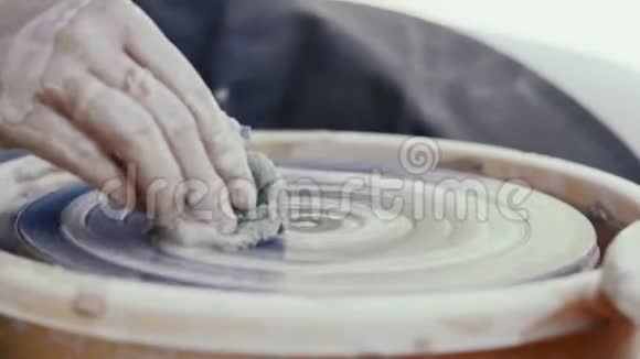 特写陶工的手从陶工的圈脉工程中清理视频的预览图