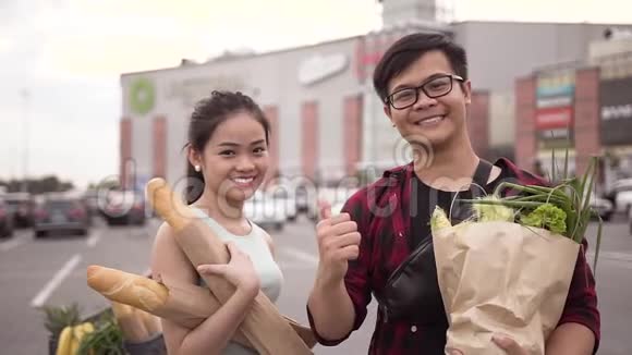 快乐开朗的越南民众拿着食品袋站在大卖场的背景下展示ok视频的预览图