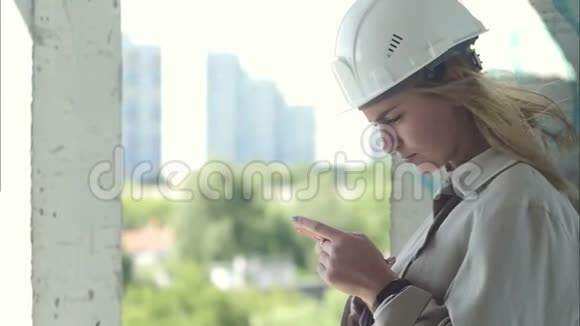 女建筑工程师手持智能手机站在施工现场视频的预览图