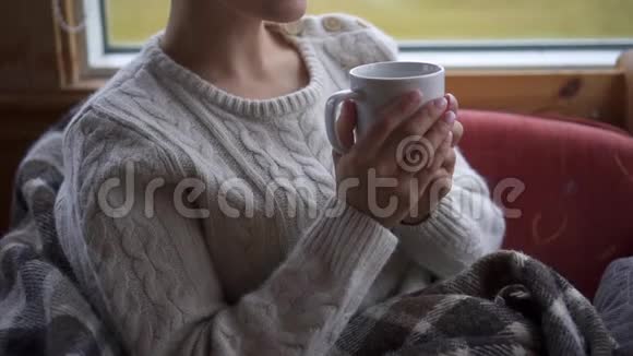 女人把一杯热茶送到嘴里的特写镜头视频的预览图