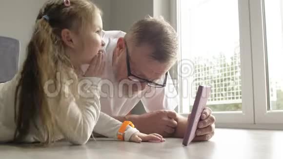 聪明的祖父在书中给他的小孙女看照片讲有趣的事实笑视频的预览图