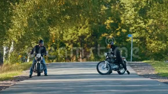 两个残暴的骑摩托车的人站在路旁准备比赛视频的预览图