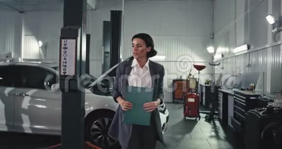 在汽车服务部门快乐而有魅力的女员工在镜头前行走在汽车服务部门感到非常兴奋视频的预览图
