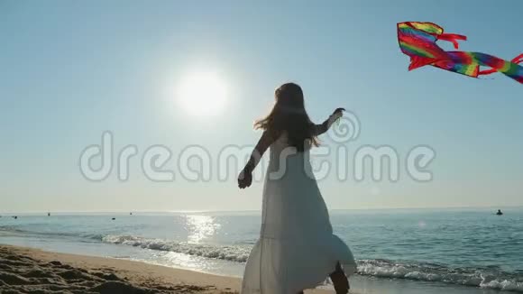 穿白色裙子的女孩在海滨玩风筝视频的预览图