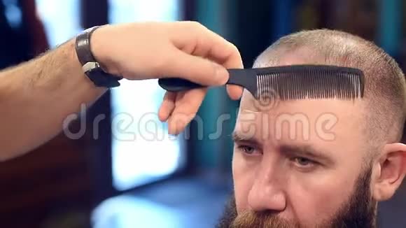 理发师的手梳理和切割前锁的头发在人的头与裁剪视图使用梳子和电动修剪机视频的预览图