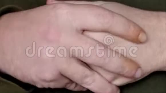 男性特写屈膝揉搓双手视频的预览图