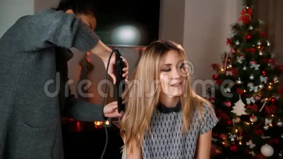 亚洲化妆师用头发矫直器和发钳使头发变直在室内装饰视频的预览图