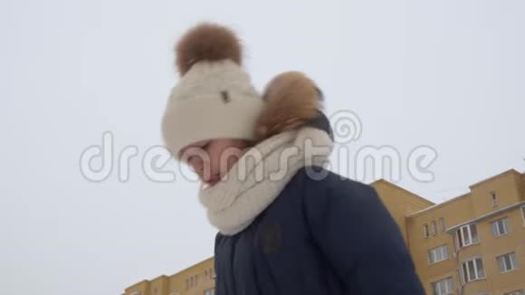 穿着冬帽围巾和外套的悲伤少女看起来有点像脚下的东西沮丧的女孩看着冬天的失落视频的预览图