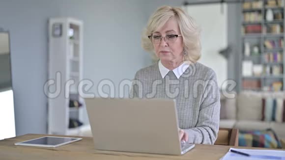 勤劳的老女人在现代办公室有头痛视频的预览图