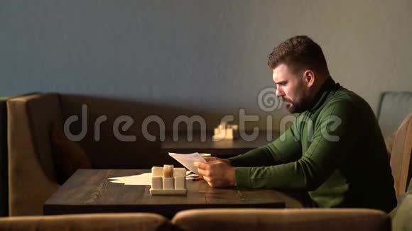 一个长胡子的商人坐在咖啡馆里检查合同视频的预览图