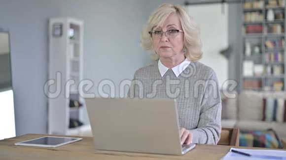疲惫的老女人在现代办公室里背疼视频的预览图