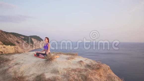 运动女孩在顶部和腿部练习瑜伽在一个风景如画的地方在自然视频的预览图