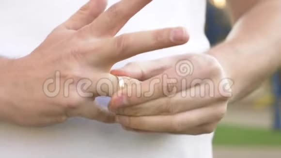 双手特写那个人在街上摘下他的结婚戒指视频的预览图