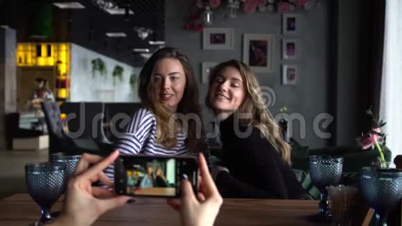 两个漂亮的女朋友拥抱在一起摆姿势拍照视频的预览图