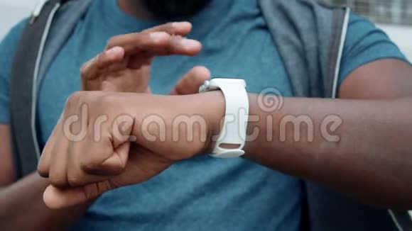 运动员的手在户外使用智能手表Jogger检查智能手表的结果视频的预览图
