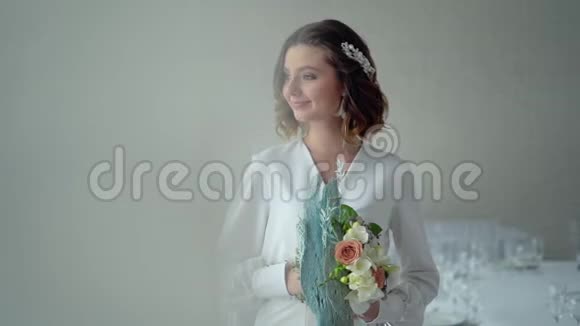 美丽的黑发新娘微笑着手里拿着一束花头发中的精美头饰专业化妆视频的预览图