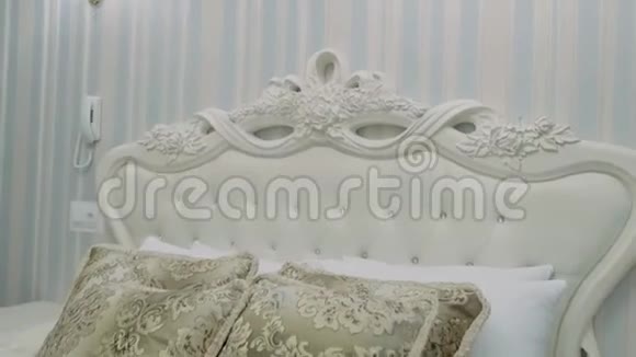 带枕头和白色床单的美丽米色床视频的预览图