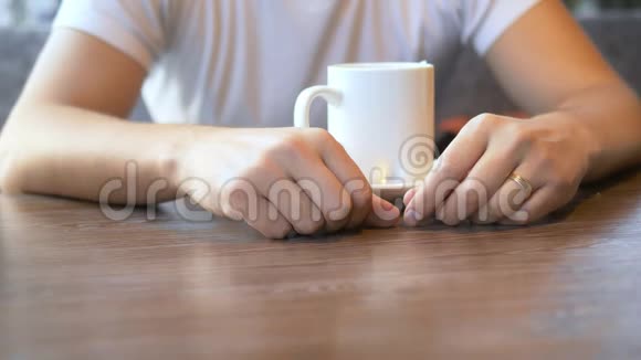 特写镜头那个人戴着结婚戒指坐在咖啡馆里视频的预览图