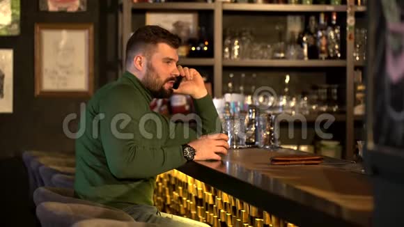 一个留着胡子的男人喝酒打电话视频的预览图