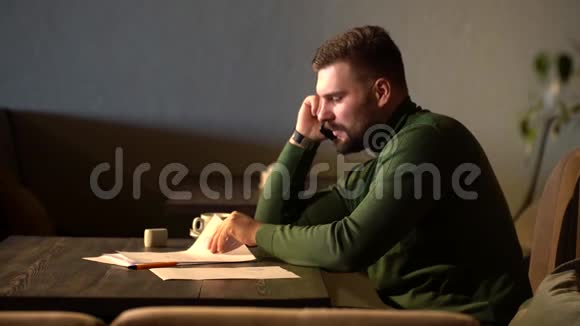 一个男商人正在一家咖啡馆里打电话讨论一份合同视频的预览图