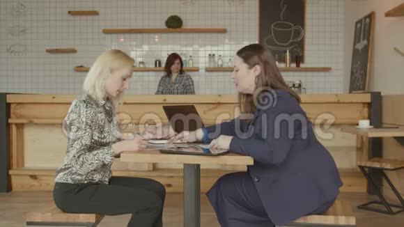 有文件和小玩意的女人在咖啡馆工作视频的预览图