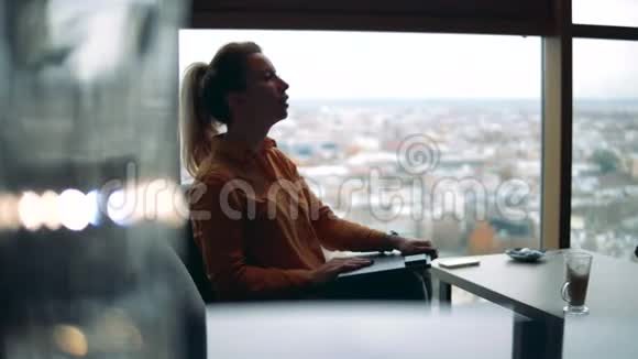 城市咖啡馆一个自由职业者女人在笔记本电脑上打字视频的预览图