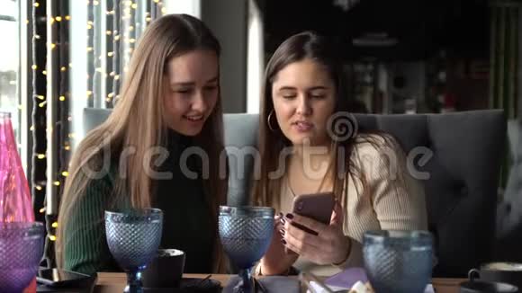 女孩在手机上展示了她的朋友的东西视频的预览图