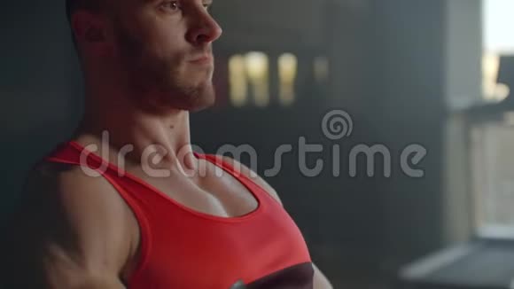 一个疲惫的运动男子坐在健身房的室内划船器上人和健身观念视频的预览图