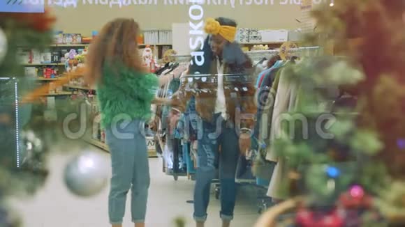 女人在假期前在商店试穿夹克视频的预览图