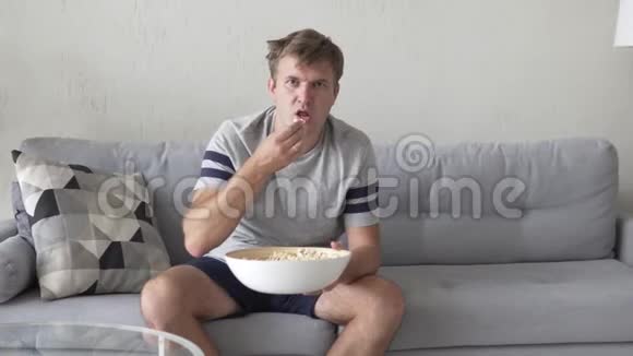 一个男人看电视吃爆米花视频的预览图